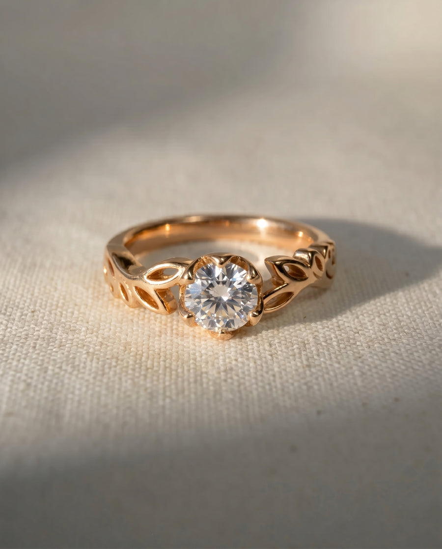 Rose gold engagement ring with a round lab-grown diamond and leaf-design band.