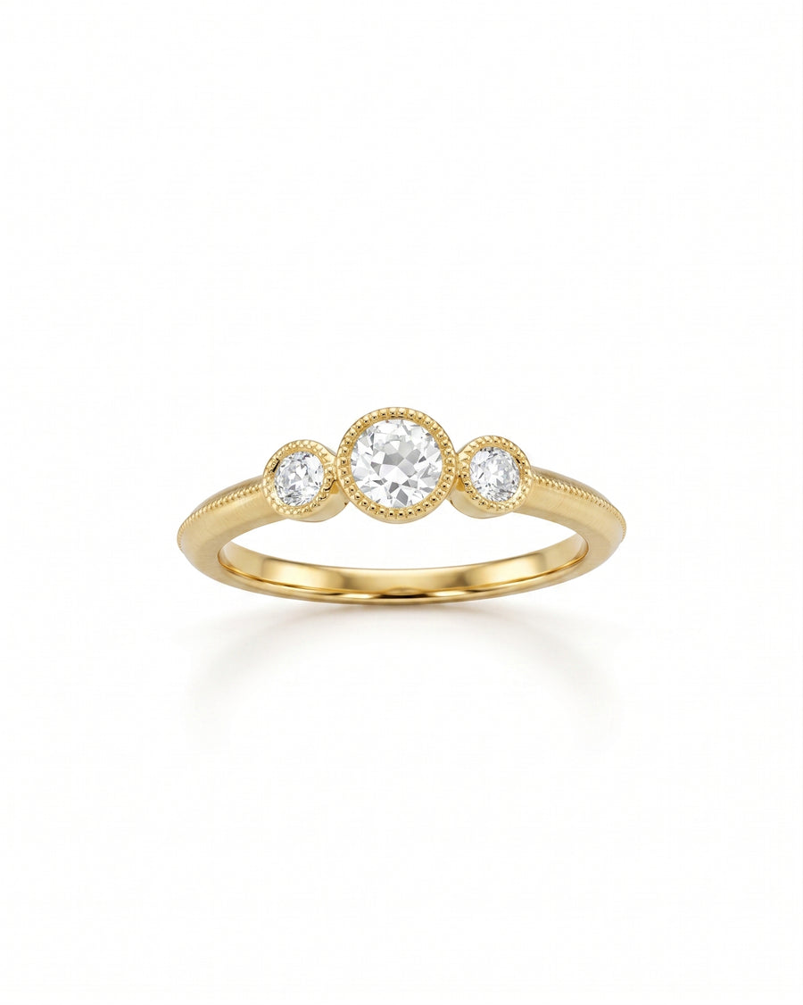 Gold ring with three round diamonds in bezel settings.