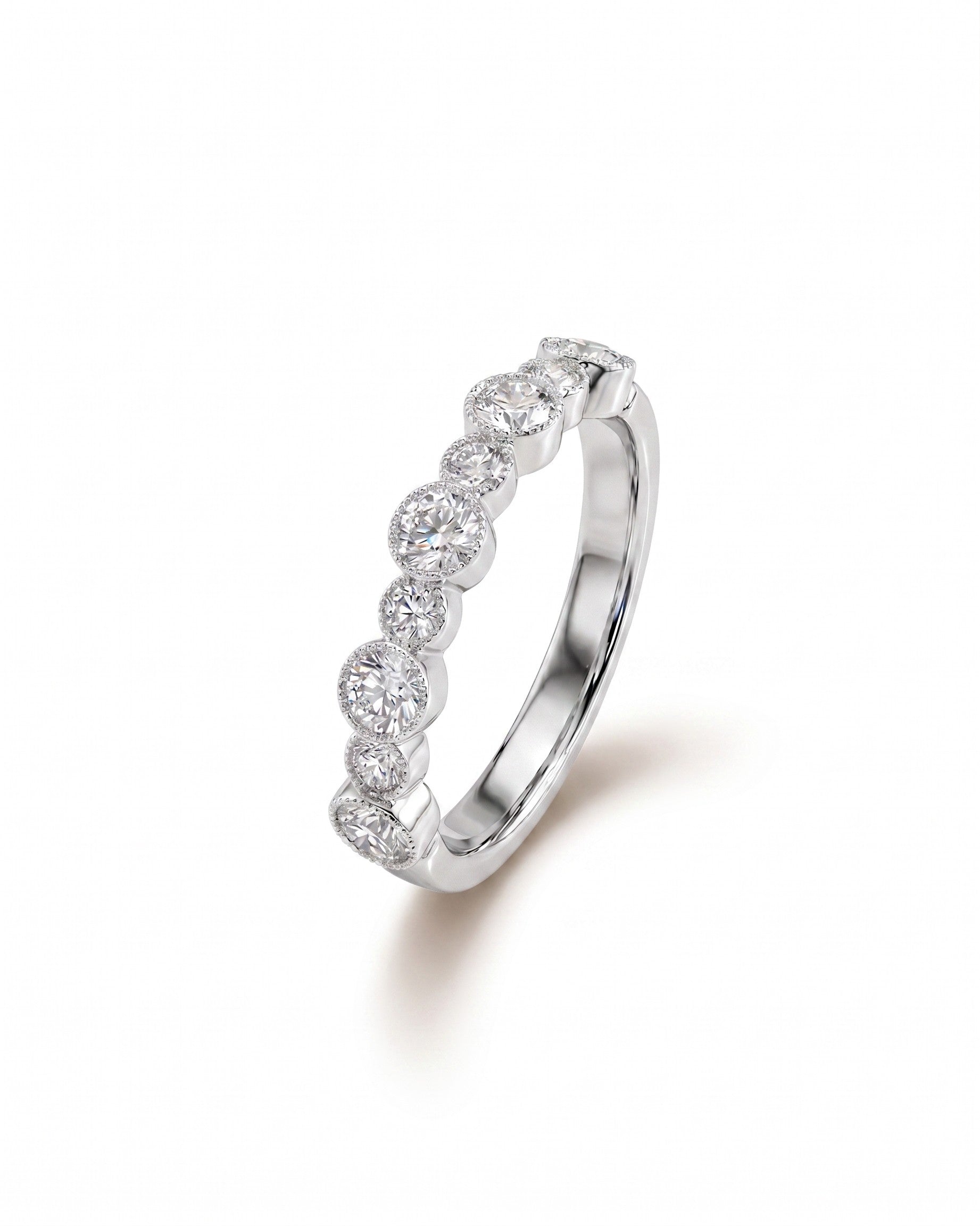 White gold eternity ring with bezel-set round diamonds.