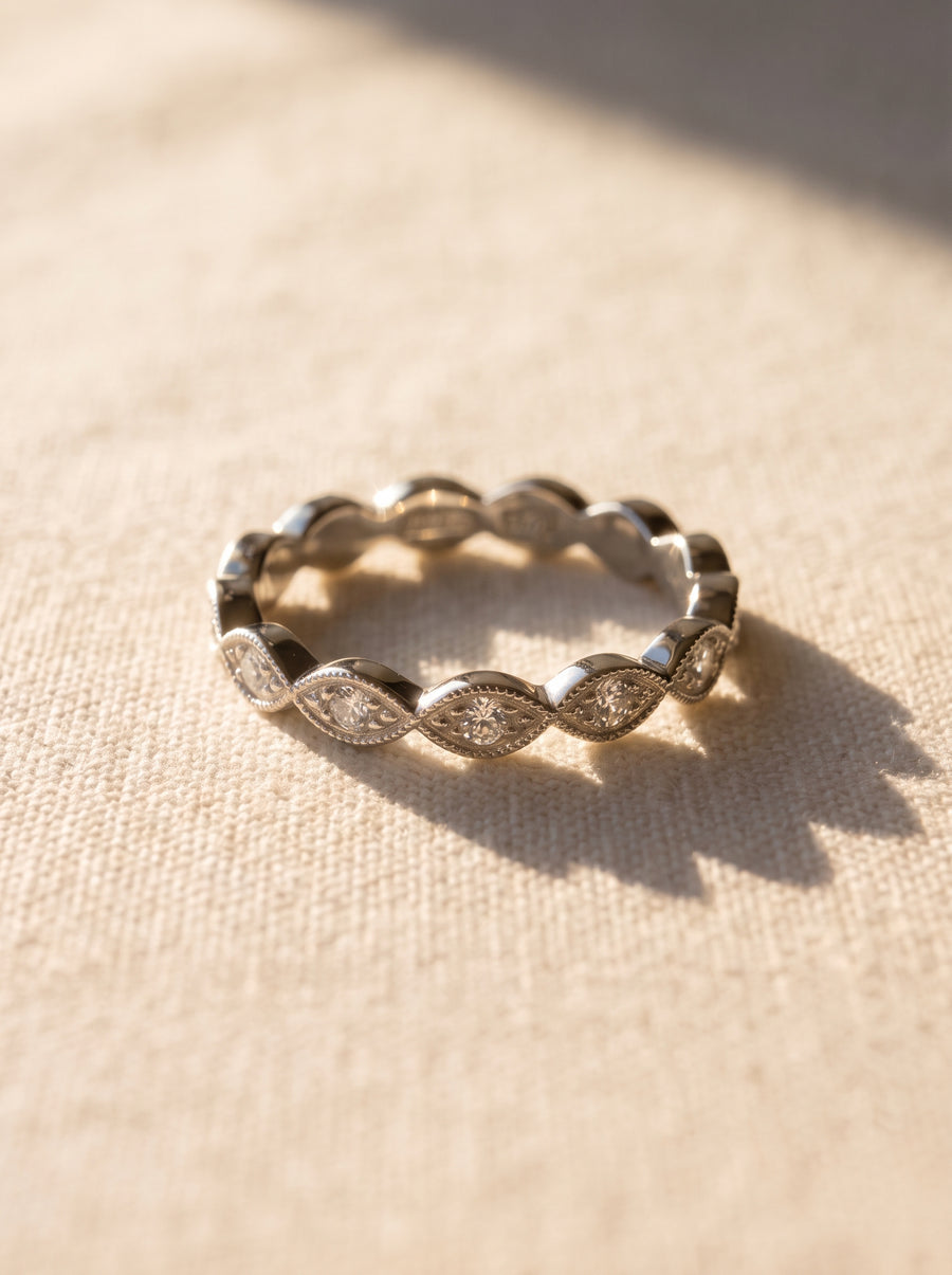 Silver eternity band featuring marquise-shaped diamonds set in a vintage-inspired milgrain metal frame.