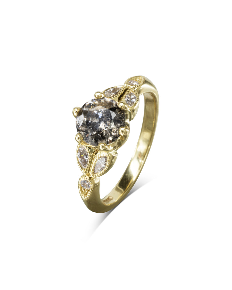 Gold engagement ring with a round salt and pepper diamond and accent diamonds.