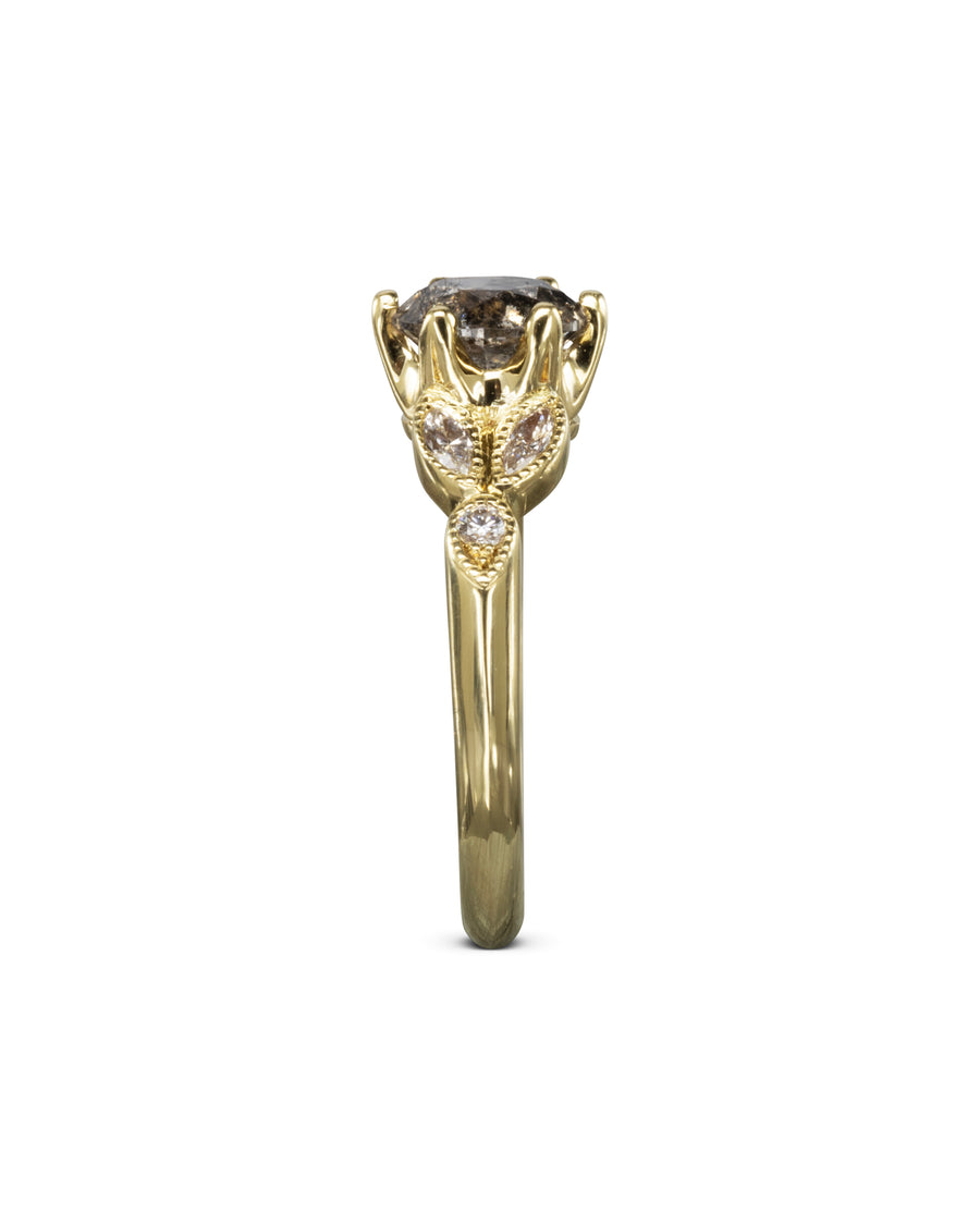 Gold engagement ring with a large salt and pepper diamond and small white diamonds.