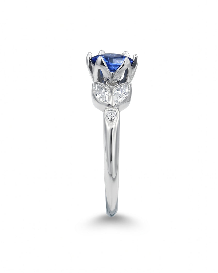 Platinum engagement ring with a round blue sapphire and diamond accents.