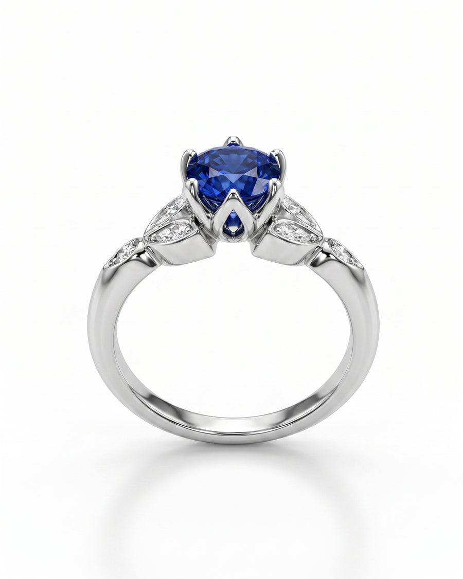 Silver ring with a round blue sapphire and diamond accents.