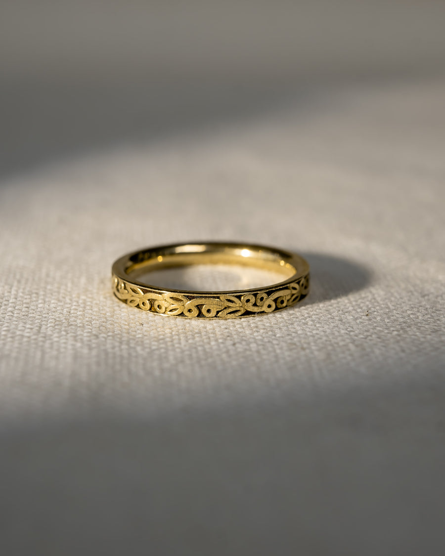 9ct yellow gold carved wedding ring with an intricate pattern.