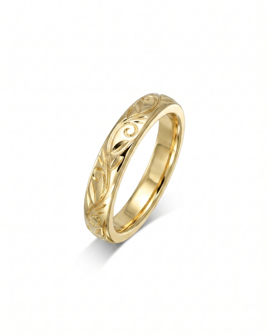 Gold wedding ring with engraved vintage floral design.