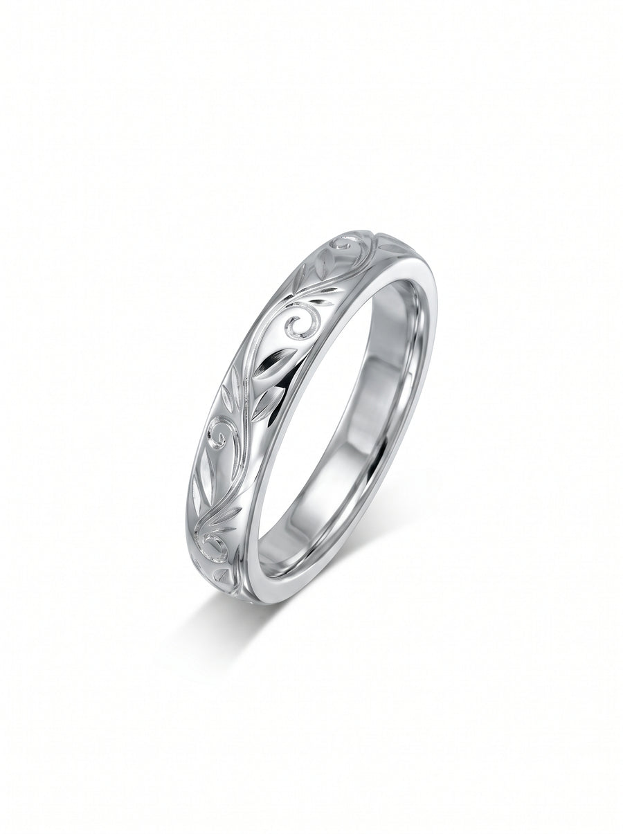 Silver wedding ring with an engraved floral scroll pattern on a polished band.