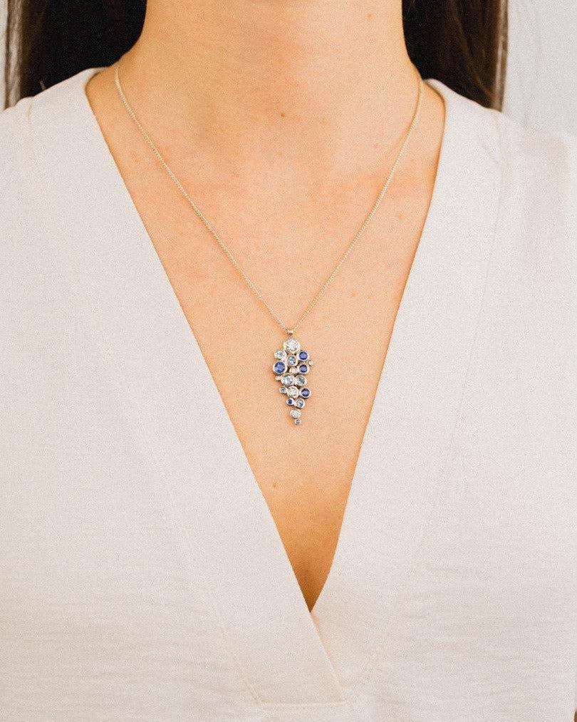 Gold chain with water bubbles cluster diamond and gemstone pendant.