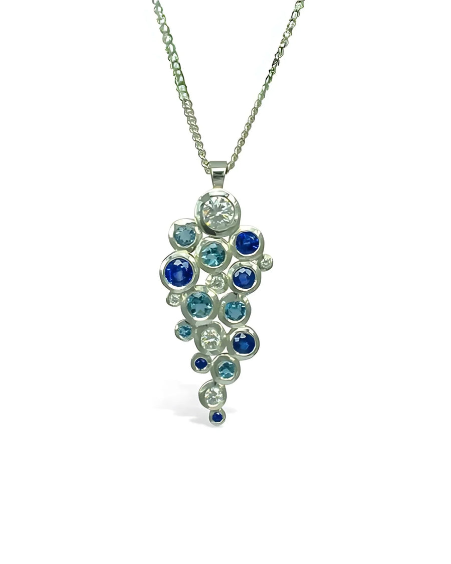 Yellow gold pendant with sapphire, aquamarine, and diamond cluster.