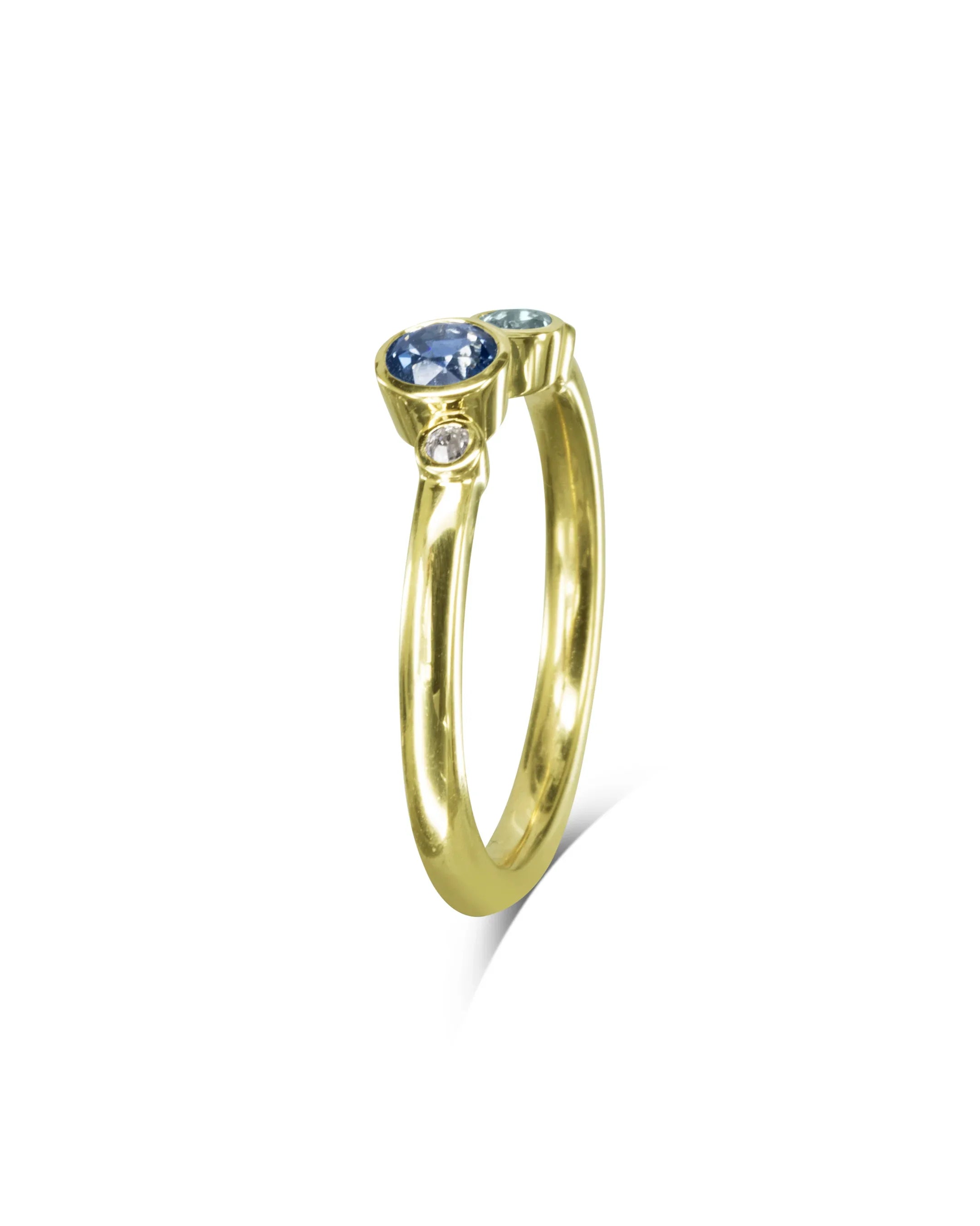 Yellow gold engagement ring with five offset sapphires and a modern minimalist design