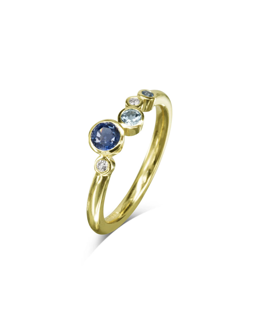 Yellow gold engagement ring with five offset sapphires and diamonds on white background