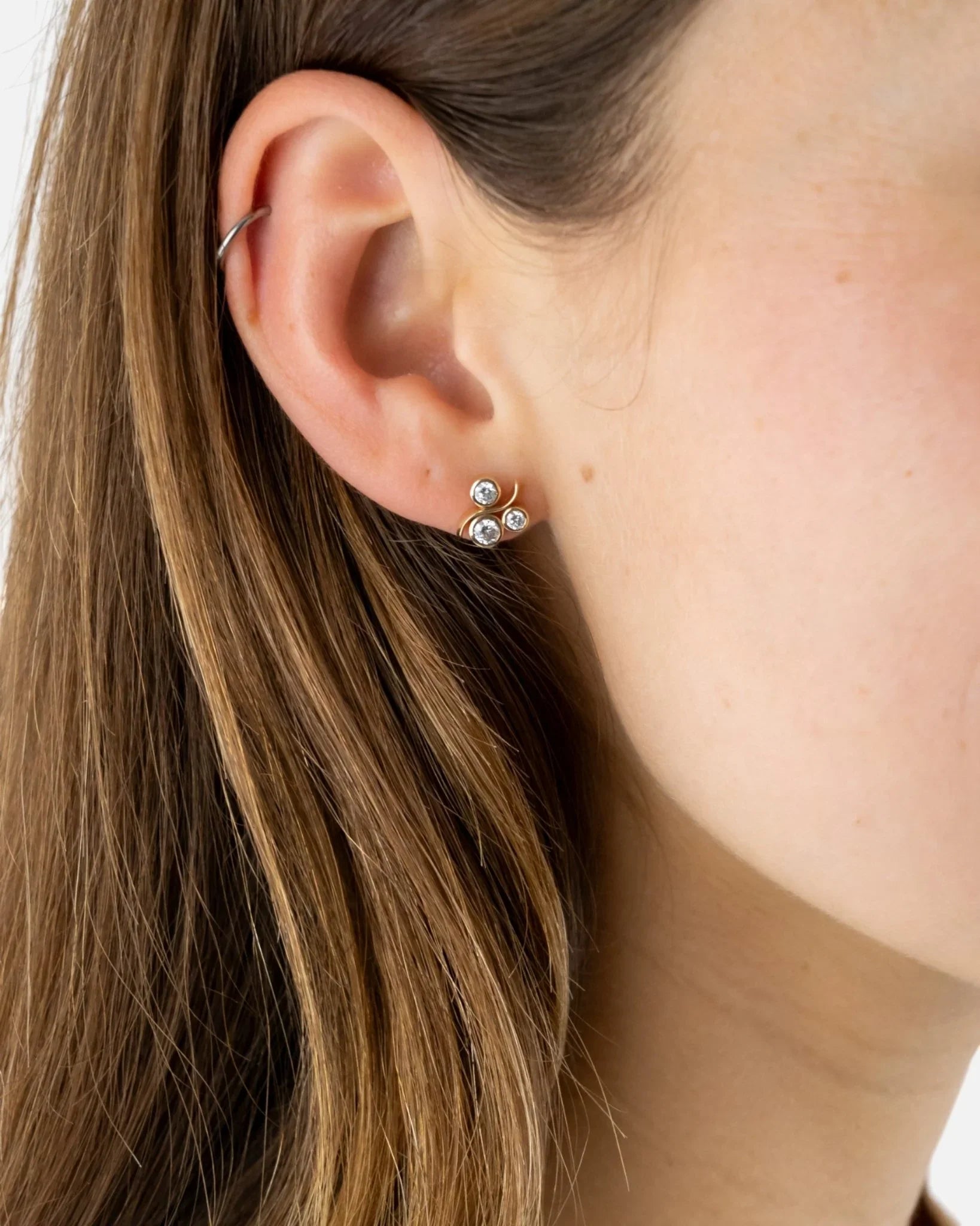Yellow gold diamond stud earrings with water bubble design on ear