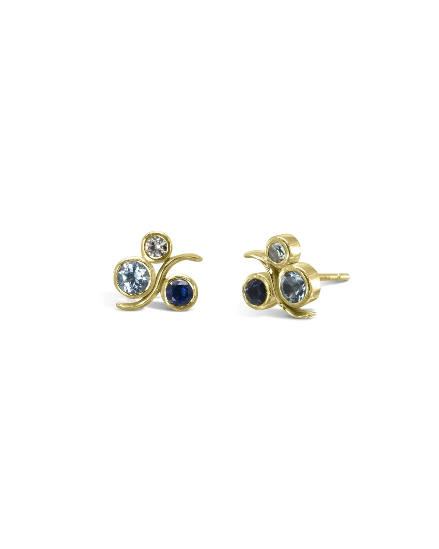 Gold stud earrings with blue and clear gemstones in an organic swirl design