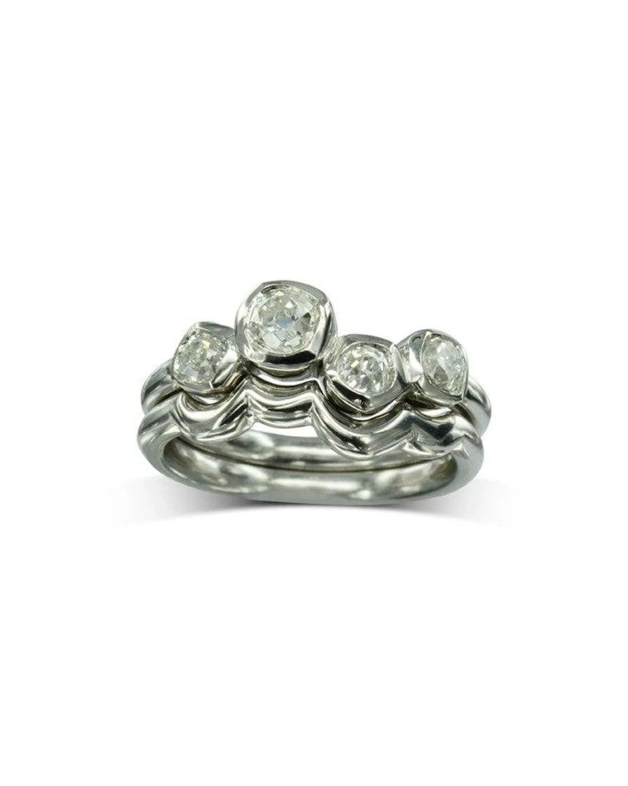 Silver wedding band set with four round diamonds in a water bubble shape.