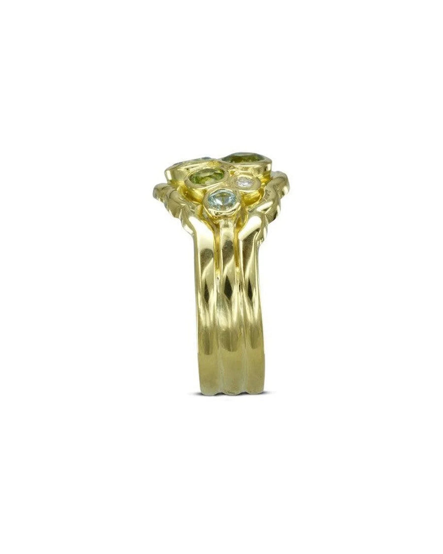 Gold wedding band with green and clear gemstones in a water bubble shape.