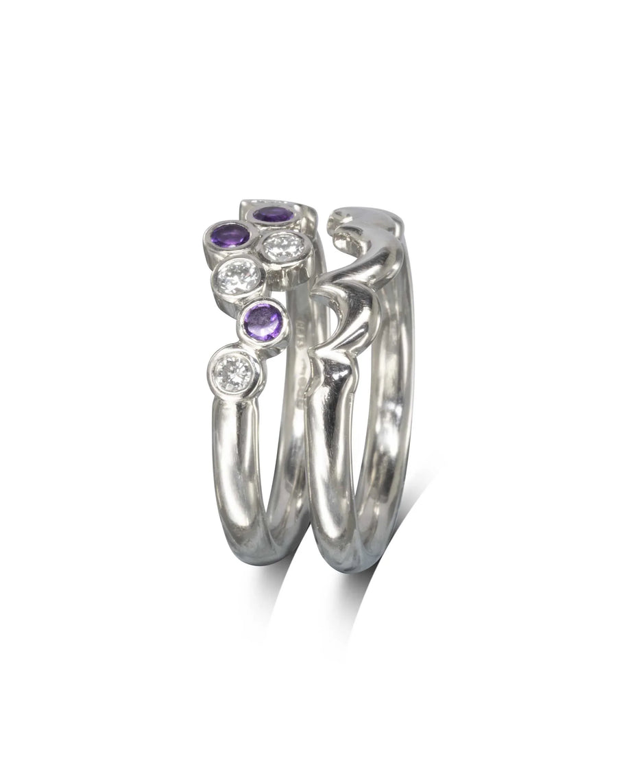 Silver wedding band with water bubble shape, round purple and clear gemstones.