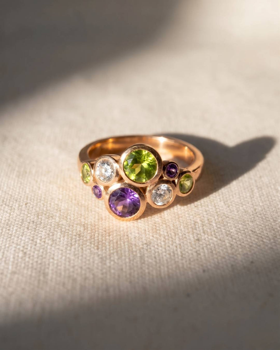 9ct yellow gold ring with peridot, amethyst, and white gemstones in a bubble design.