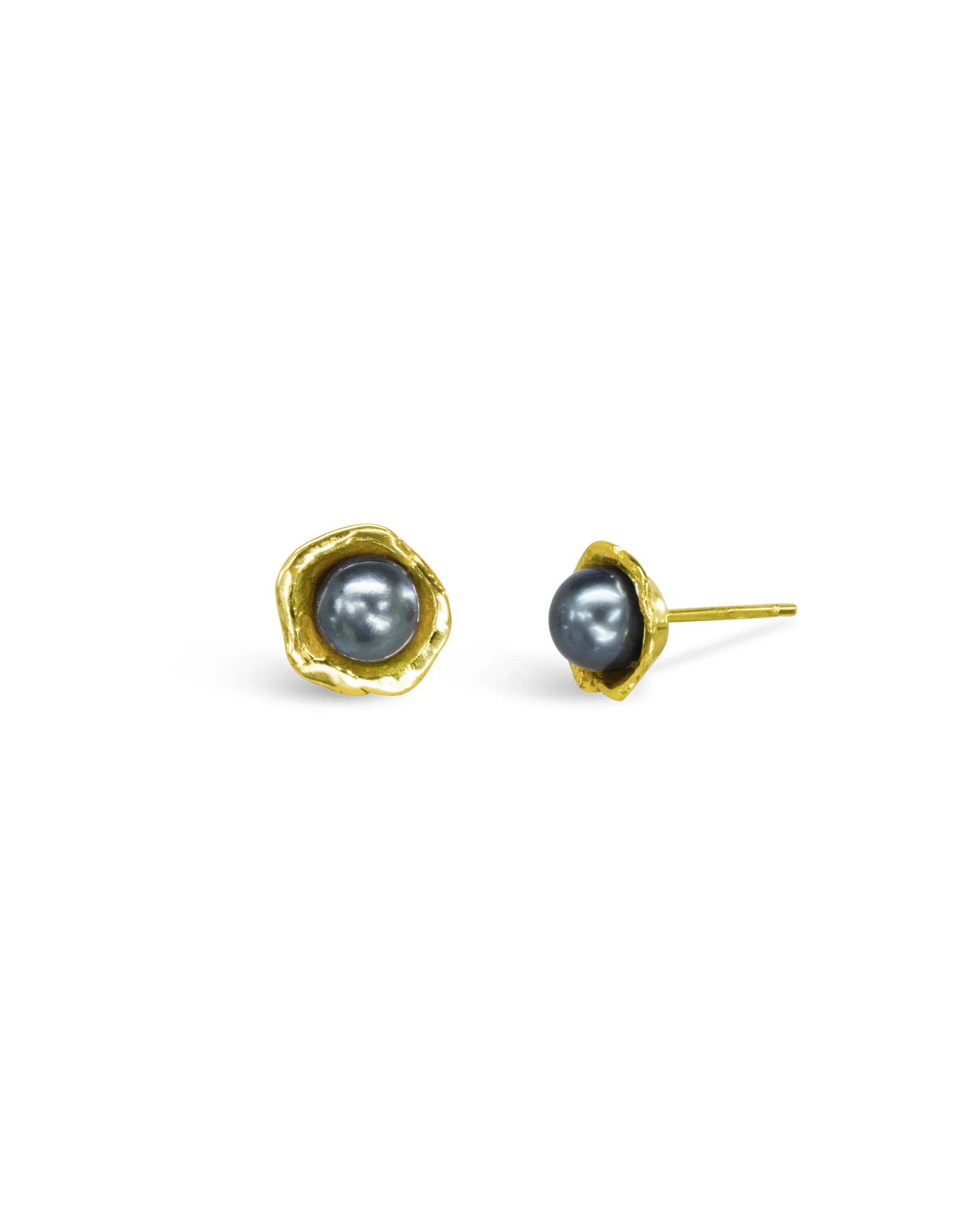 Gold ear studs with dark pearls and rugged, organic edges on a white background
