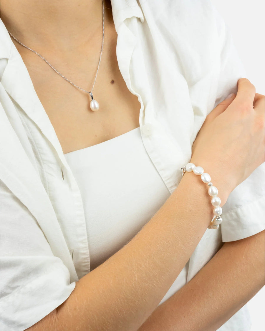 Woman wearing a freshwater pearl necklace and matching pearl bracelet