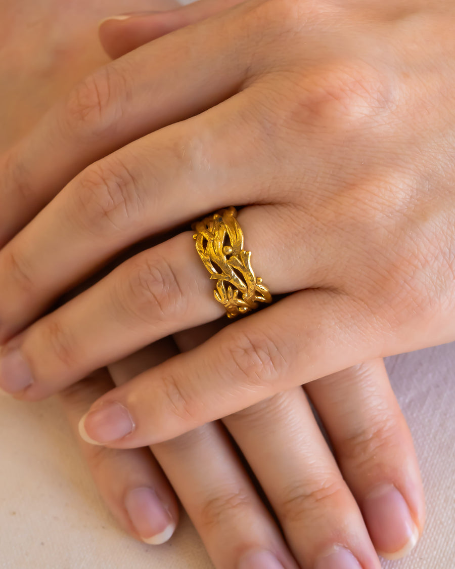 Handmade gold wedding ring with organic, textured design on a woman's hand