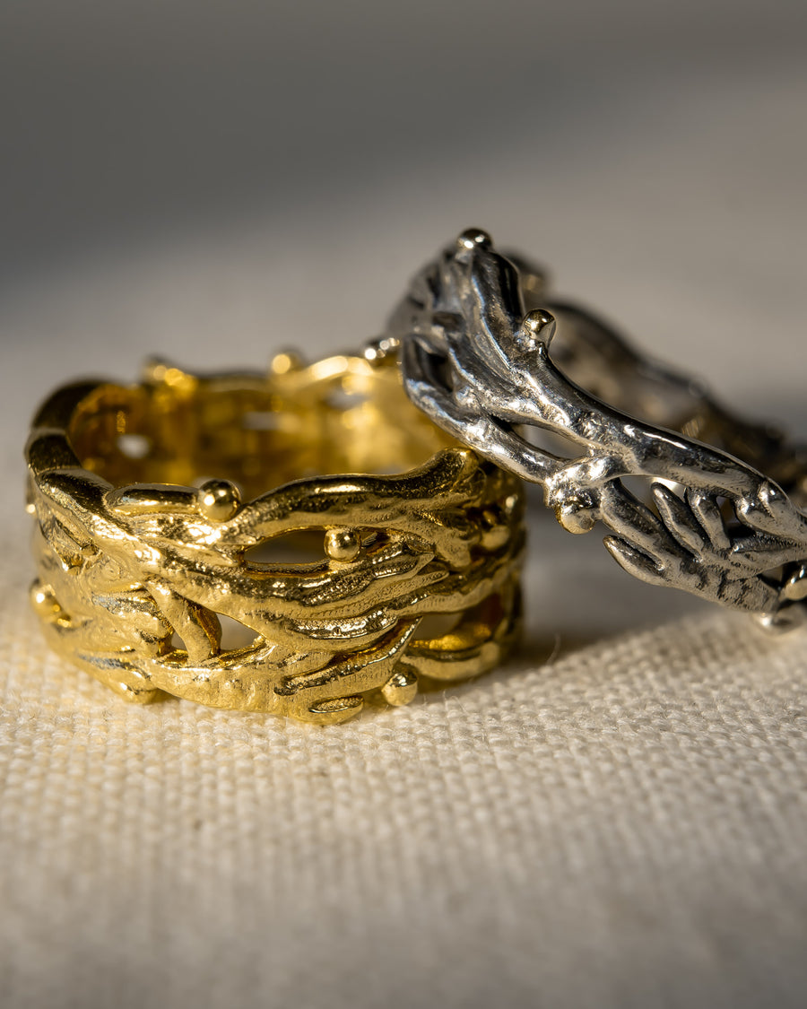 Gold and silver textured wedding rings with organic, handcrafted design on fabric