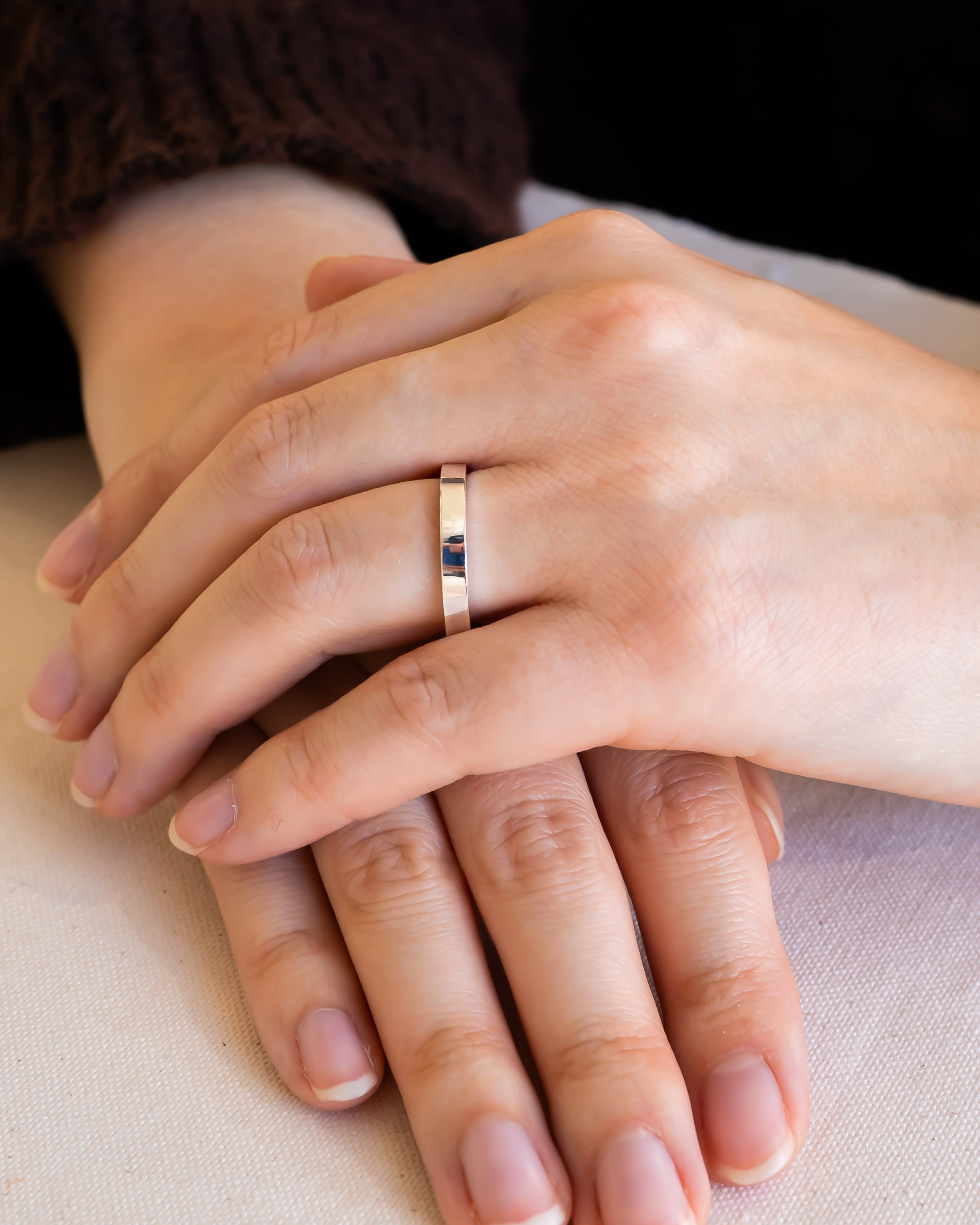 Simple gold wedding ring on hand, symbolizing commitment and love