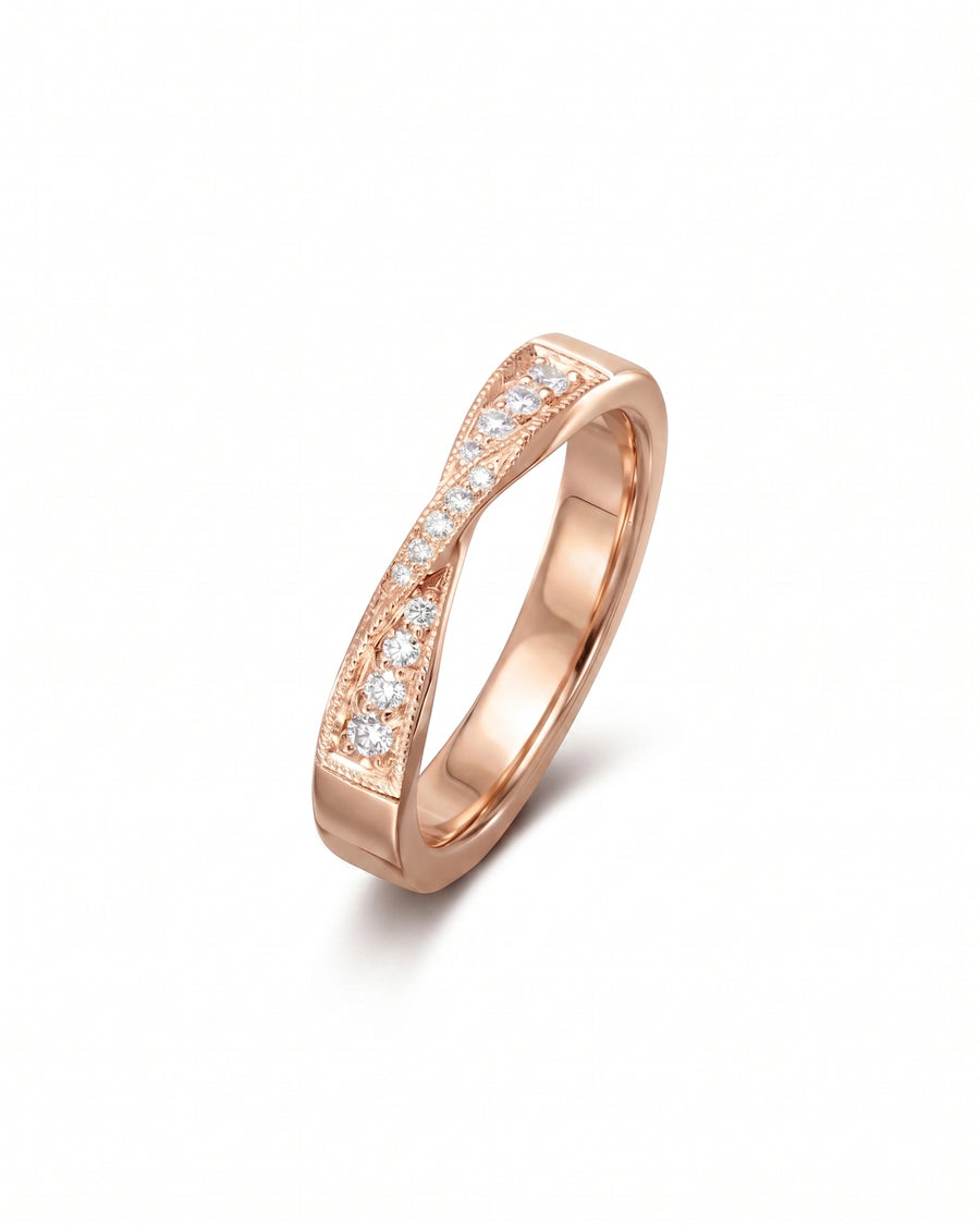 Rose gold twist diamond ring with milgrain detailing.