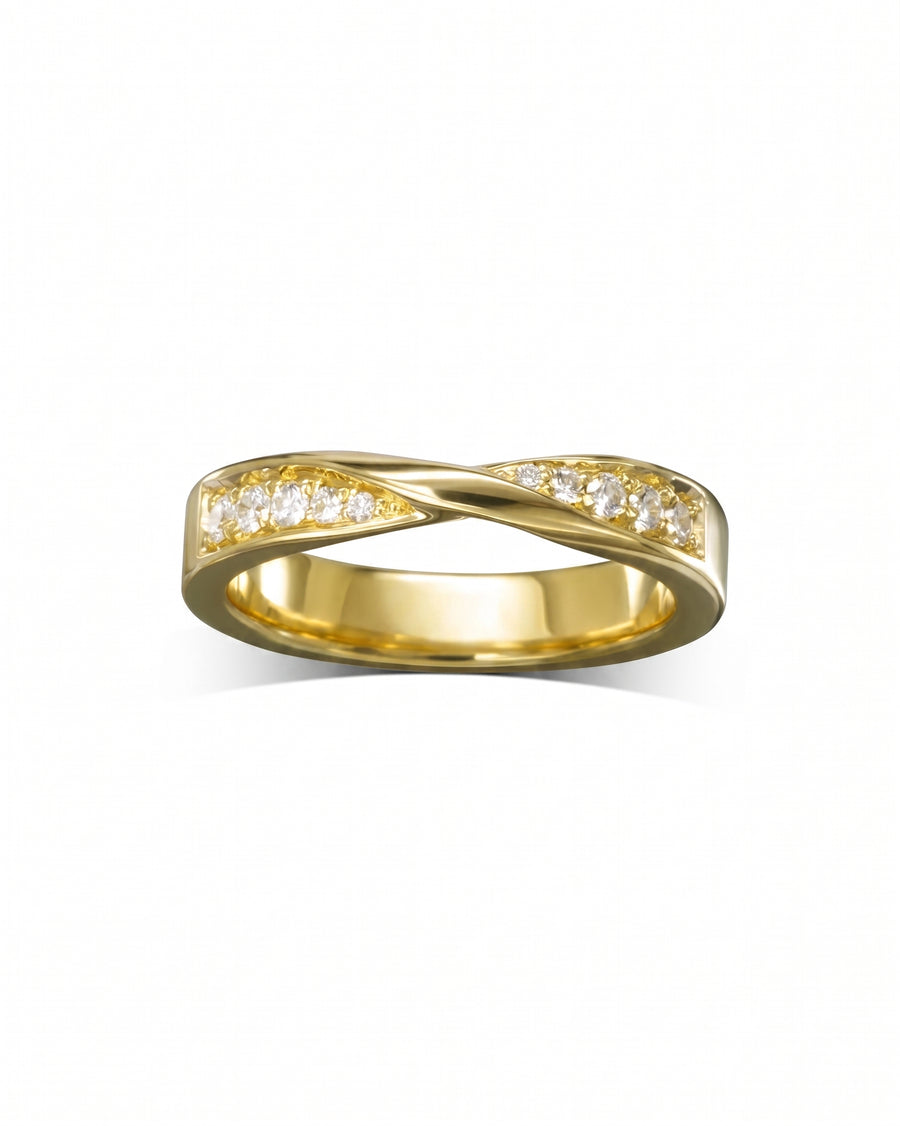 Gold wedding ring with a twisted band and clear gemstones.