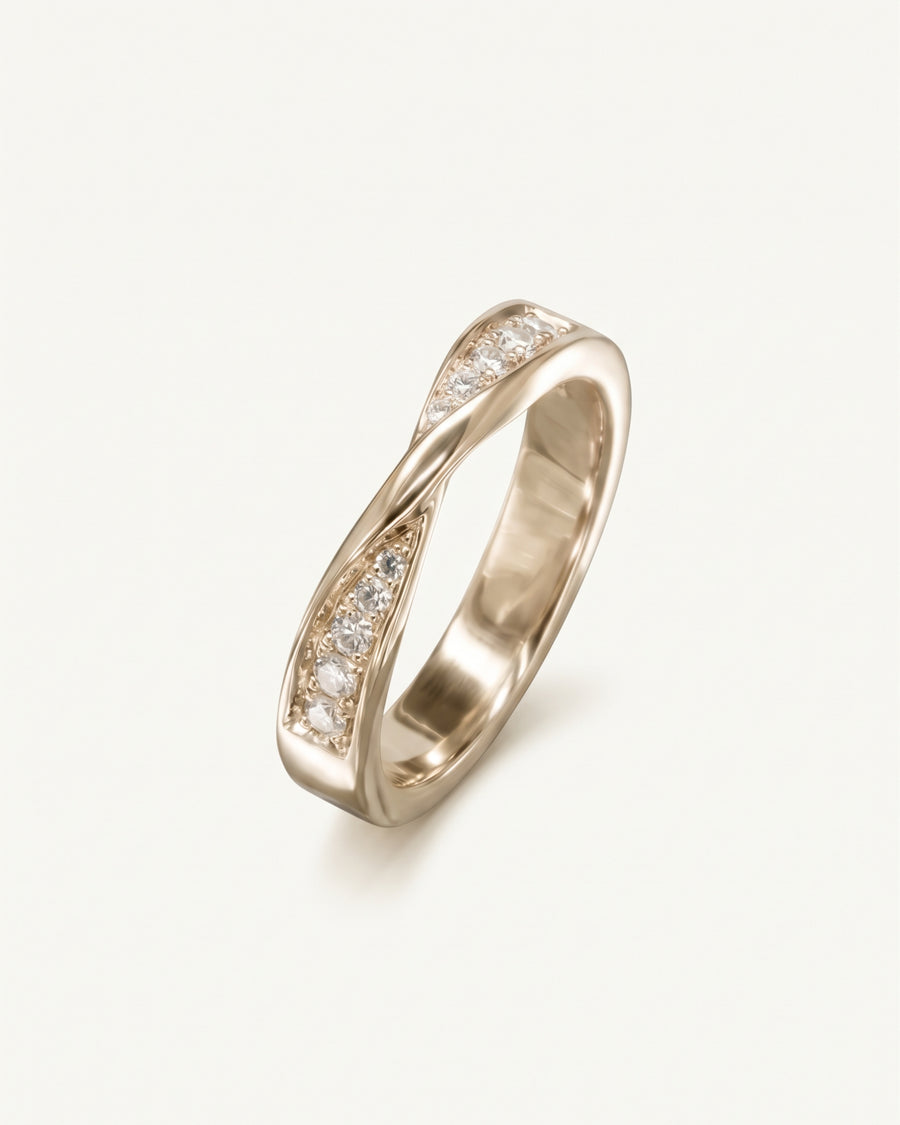 Rose gold wedding ring with a twisted band and channel-set round diamonds.
