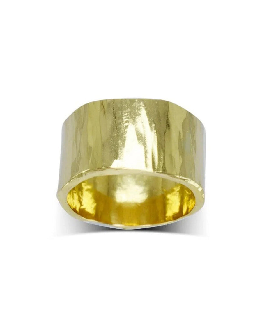 Wide gold hammered wedding ring with organic, textured finish on white background
