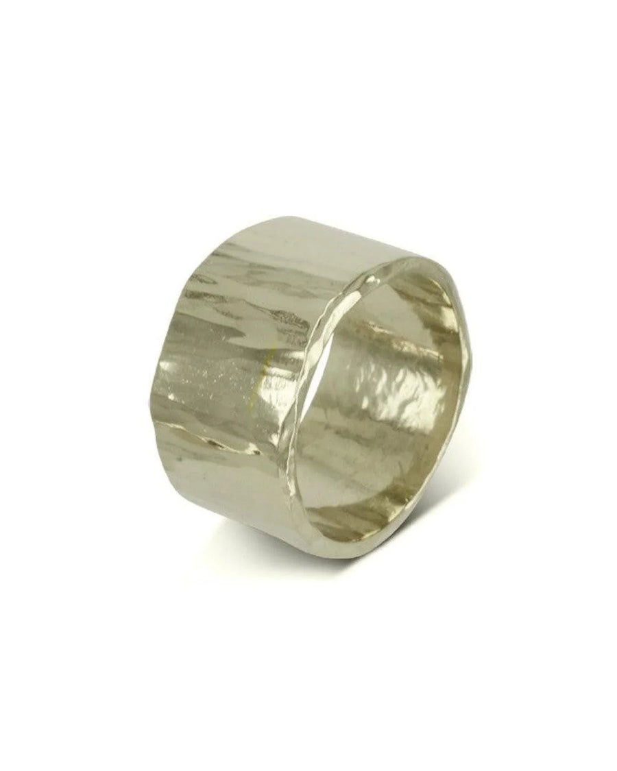 Wide hammered gold wedding ring with organic textured finish on white background