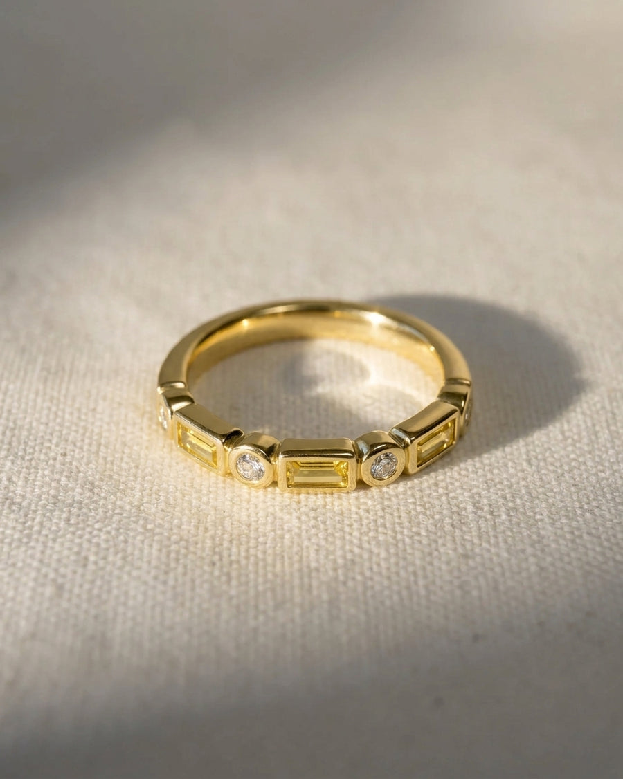 Gold eternity ring with yellow sapphires and round diamonds.