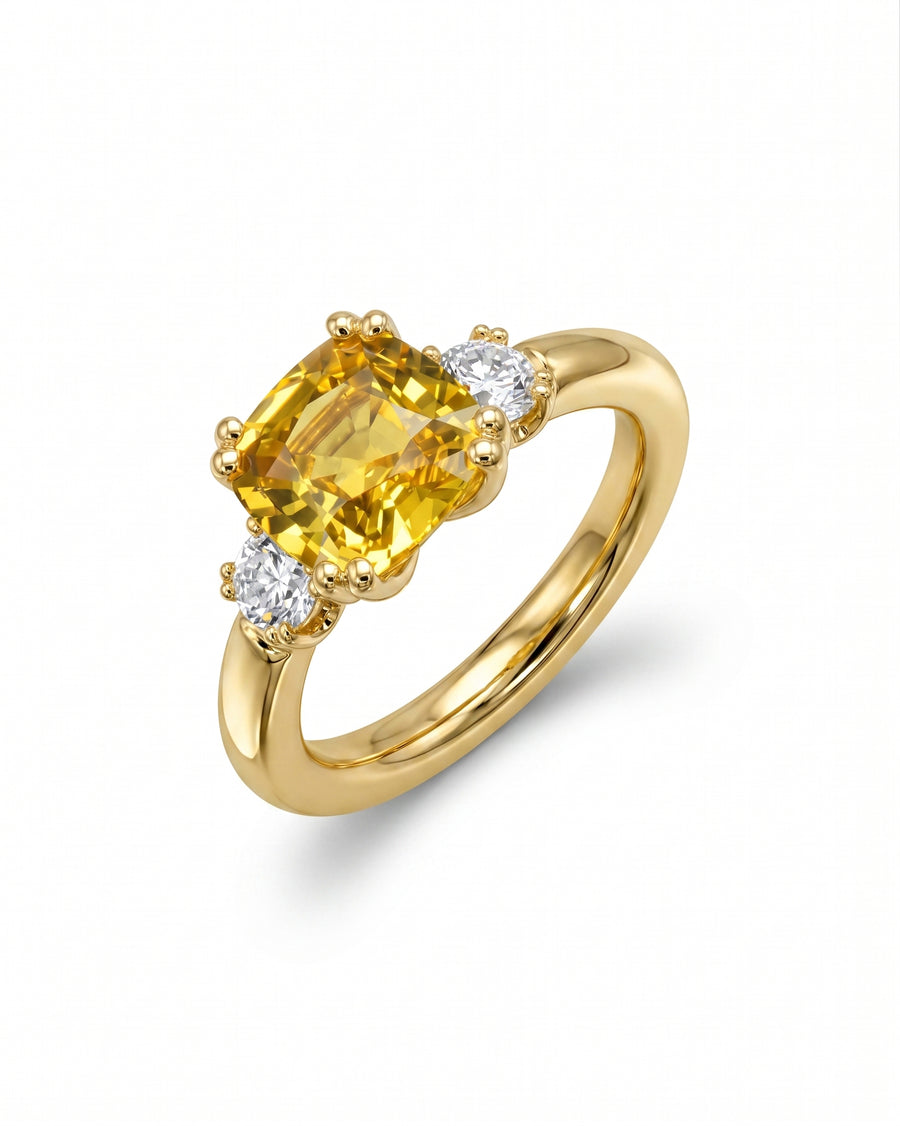 Yellow sapphire engagement ring with two side diamonds set in yellow gold.