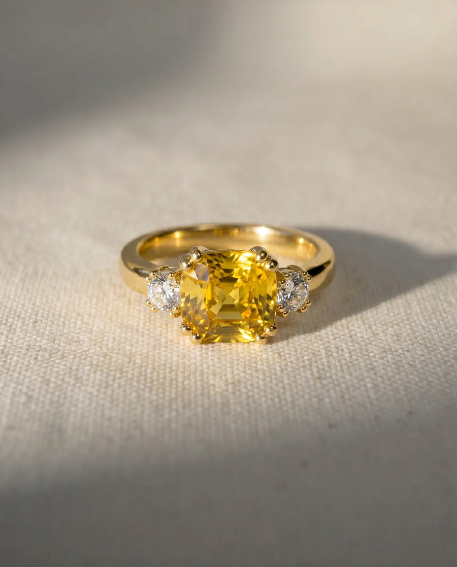 Gold ring with a large yellow sapphire and two round diamonds.