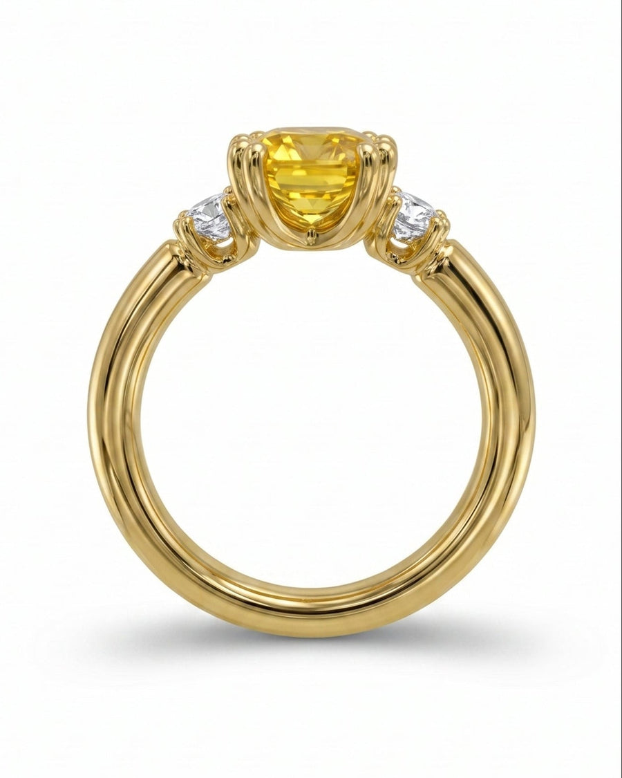 Gold ring with a cushion-cut yellow sapphire and two round white diamonds.